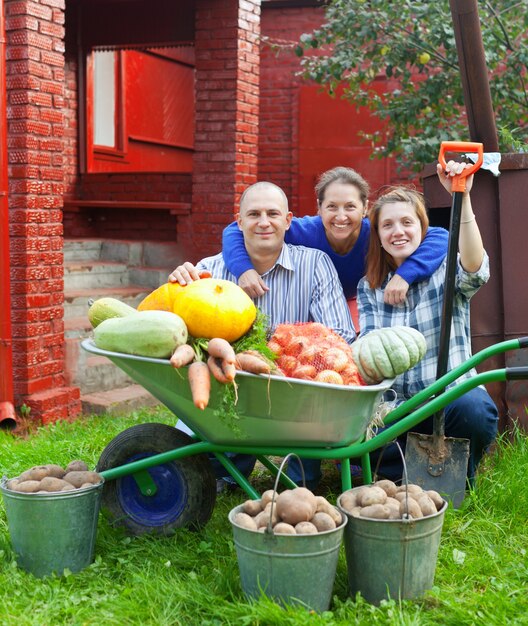 Familia feliz con cosecha de hortalizas