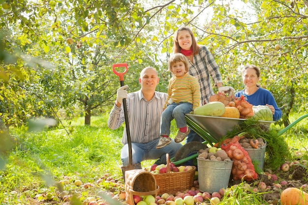 Familia feliz con la cosecha en el jardín