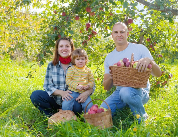 Familia feliz con cosecha de manzana