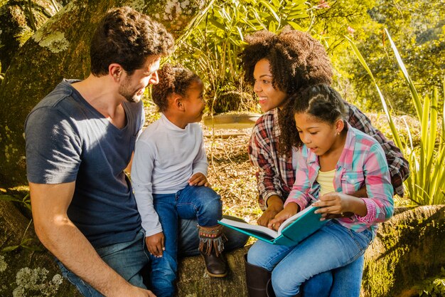 Familia feliz debajo de un árbol