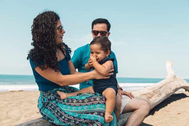 Familia feliz descansando en la orilla del mar