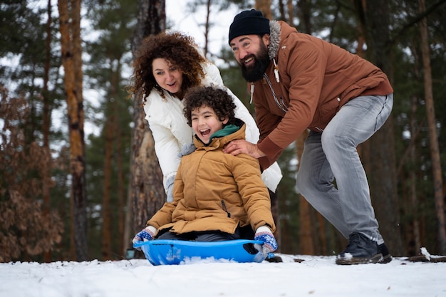 Familia feliz divirtiéndose al aire libre tiro completo