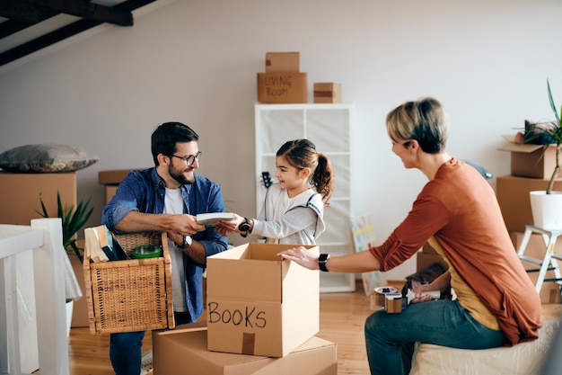 Foto gratuita familia feliz divirtiéndose mientras desempaca sus pertenencias en un apartamento nuevo