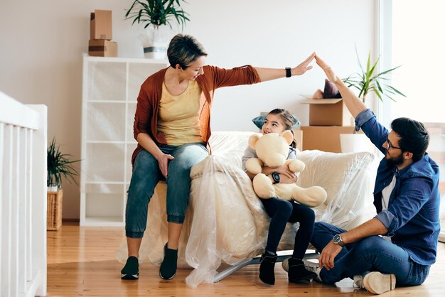 Familia feliz divirtiéndose mientras se muda a su nuevo hogar