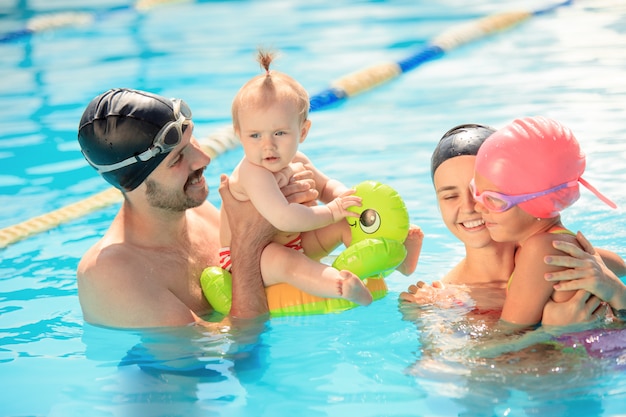 Familia feliz divirtiéndose en la piscina.