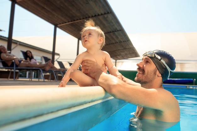 Familia feliz divirtiéndose en la piscina