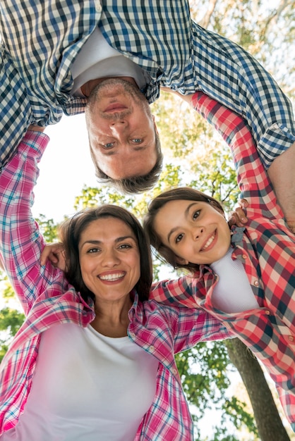 Familia feliz formando grupo en el parque contra el cielo