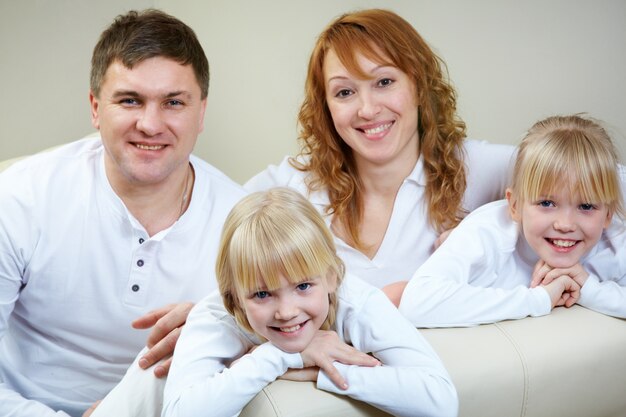 Familia feliz con las gemelas en el sofá