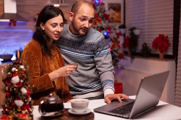 Familia feliz haciendo compras en línea comprando regalo de Navidad con tarjeta de crédito