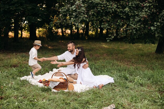 Familia feliz haciendo un picnic al aire libre con su lindo hijo