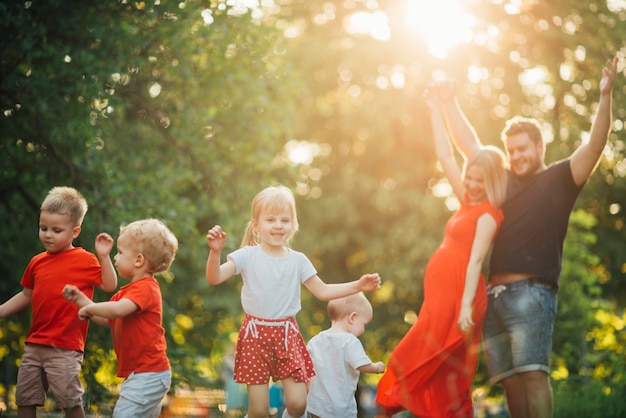 Foto gratuita familia feliz joven que se divierte en el parque