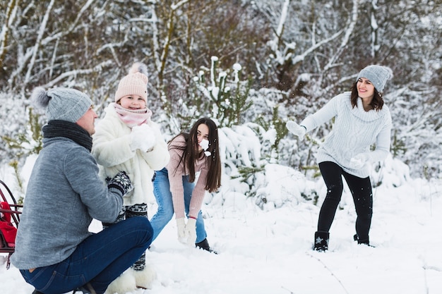 Familia feliz jugando bolas de nieve