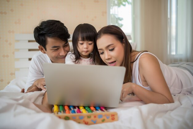 familia feliz jugando en la cama