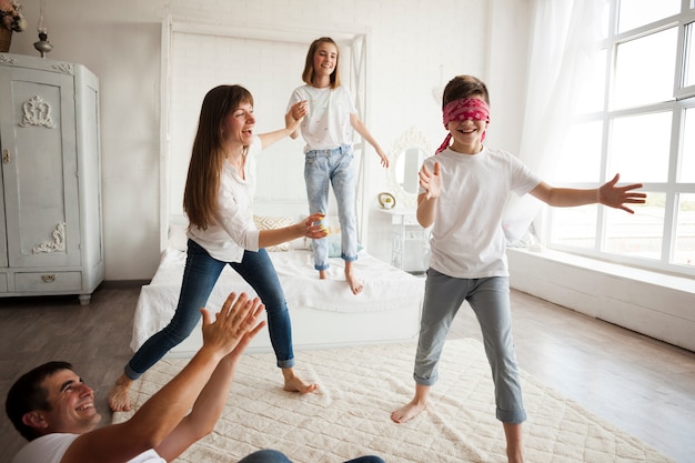 Familia feliz jugando a los ciegos en casa