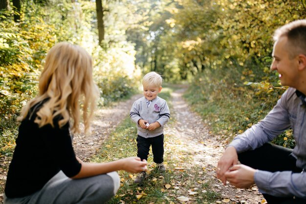 Familia feliz jugando y riendo en el parque otoño