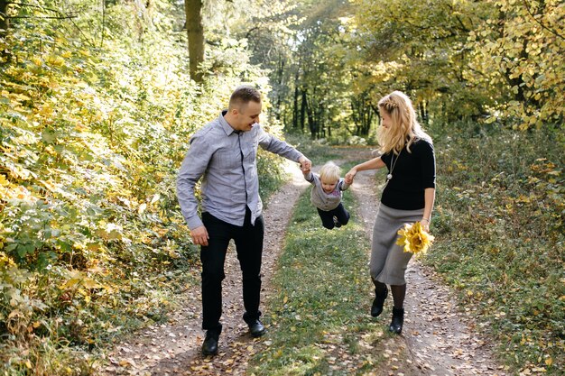 Familia feliz jugando y riendo en el parque otoño