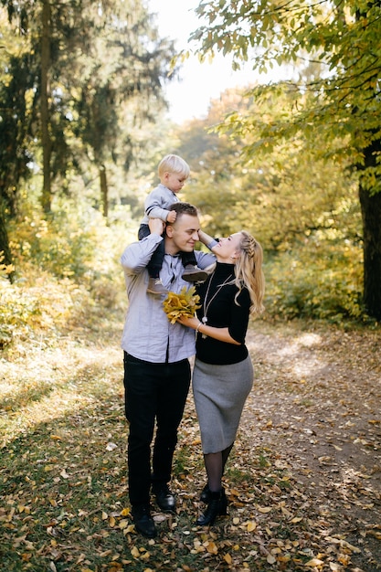 Familia feliz jugando y riendo en el parque otoño