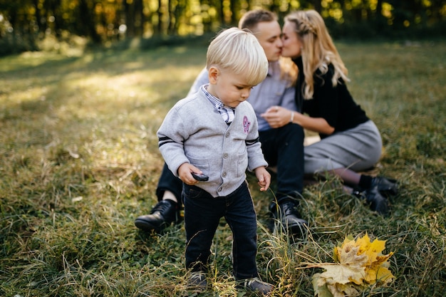 Familia feliz jugando y riendo en el parque otoño