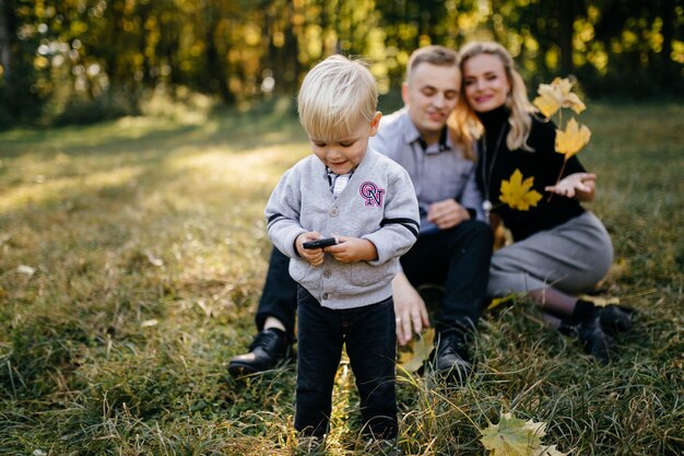 Familia feliz jugando y riendo en el parque otoño