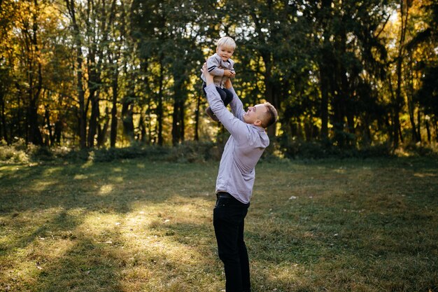 Familia feliz jugando y riendo en el parque otoño