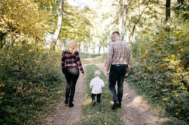 Familia feliz jugando y riendo en el parque otoño