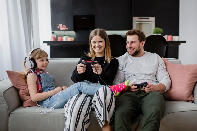 Familia feliz jugando videojuegos en el sofá