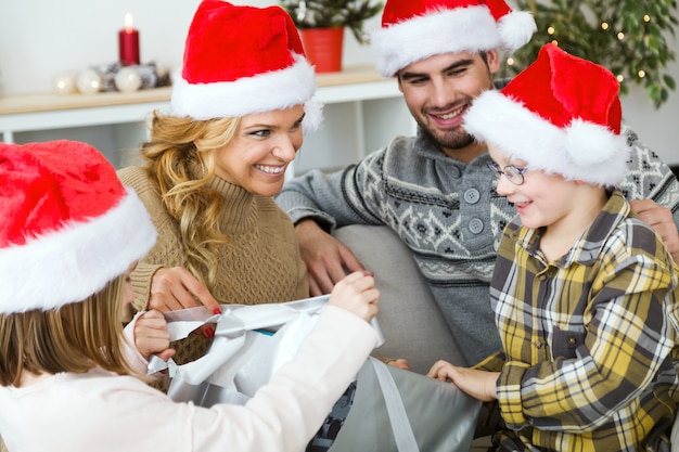 Familia feliz junta en navidad con sombreros de papa noel