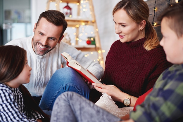 Familia feliz leyendo un libro en Navidad