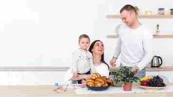 Foto gratuita familia feliz con niño en la cocina y espacio de copia