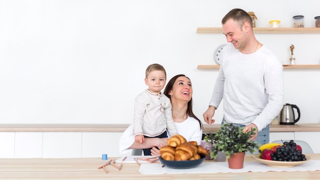 Familia feliz con niño en la cocina y espacio de copia