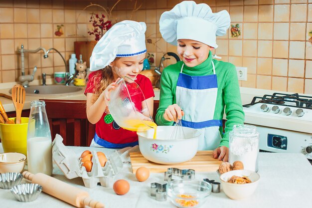 familia feliz niños divertidos están preparando la masa, hornear galletas en la cocina