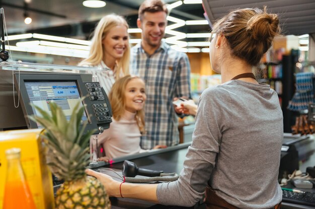 Familia feliz pagando con tarjeta de crédito