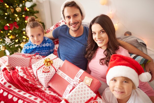 Familia feliz pasando la Navidad en la cama