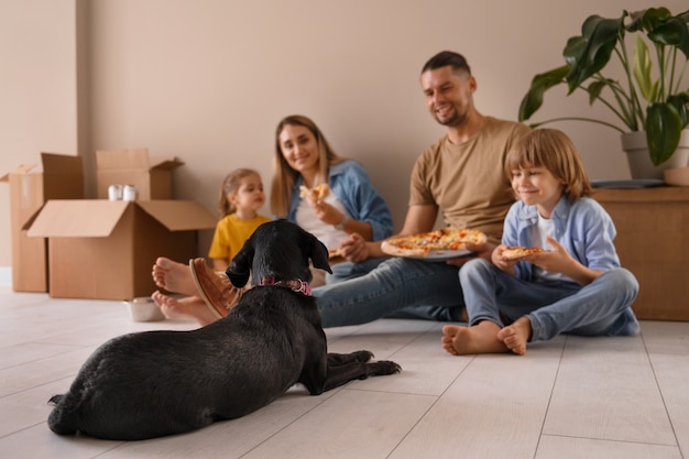 Familia feliz con perro mudándose a un nuevo hogar