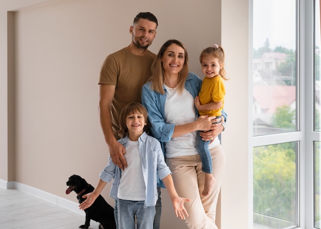 Familia feliz con perro mudándose a un nuevo hogar