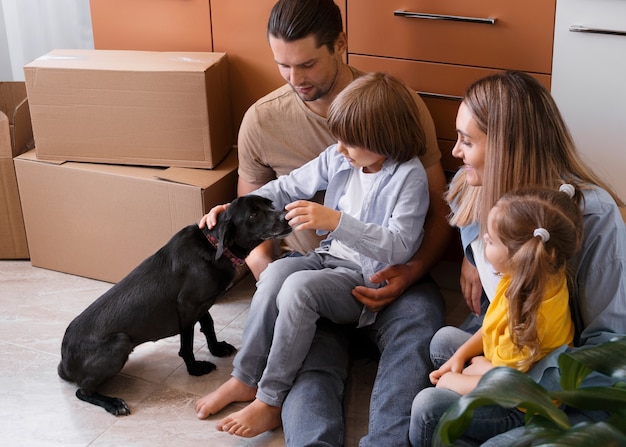 Familia feliz con perro mudándose a un nuevo hogar