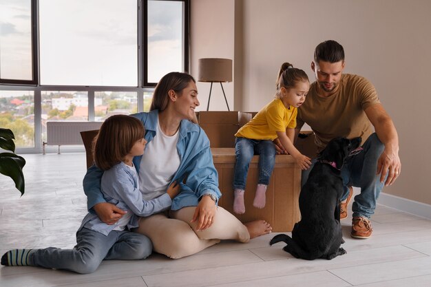 Foto gratuita familia feliz con perro mudándose a un nuevo hogar