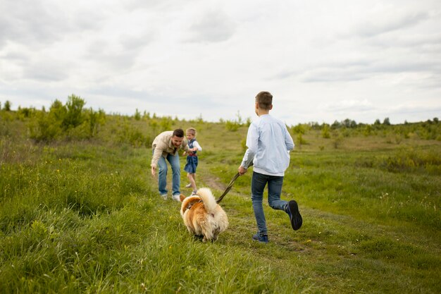 Familia feliz con perro en la naturaleza