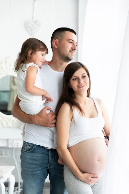 Familia feliz de pie junto a la ventana