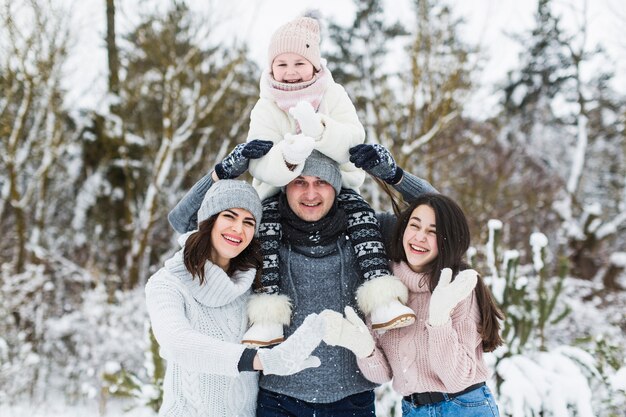 Familia feliz posando en el bosque de invierno