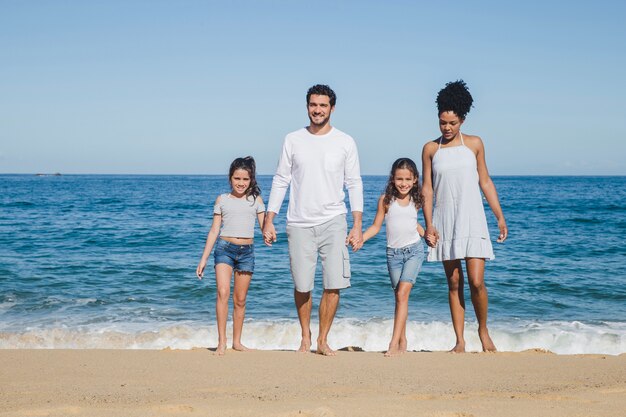 Familia feliz posando cogidos de la mano