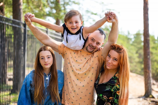 Familia feliz en posar la naturaleza contra la del bosque