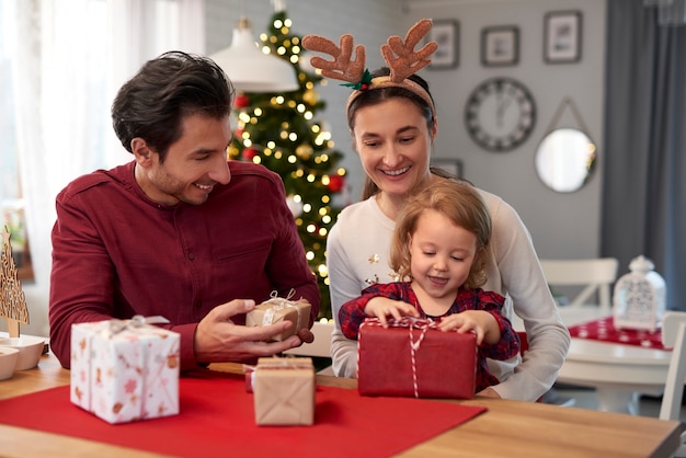 Familia feliz con regalos de Navidad en casa