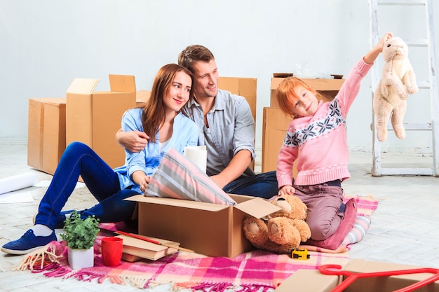 La familia feliz en reparación y reubicación. La familia planea acomodarse en cajas.