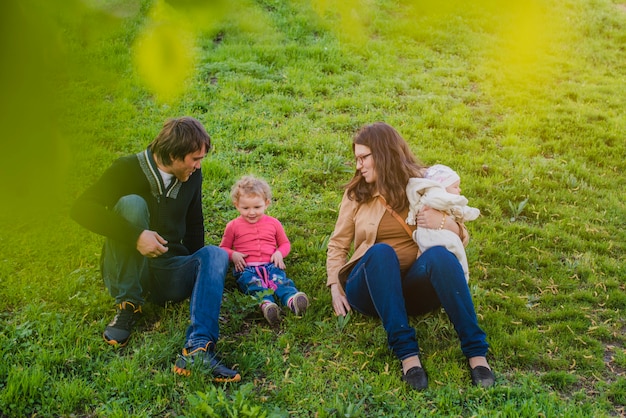 Familia feliz sentada en el césped