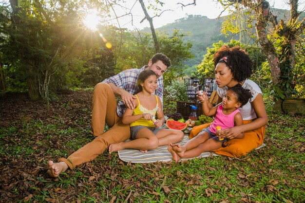 Familia feliz sentada en el césped