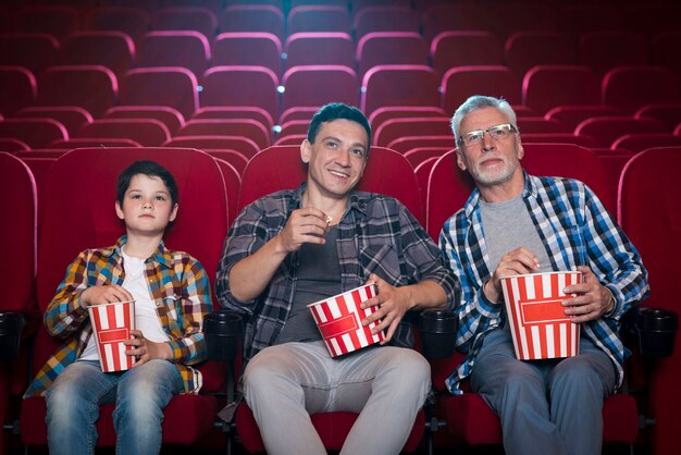 Familia feliz sentada en cine