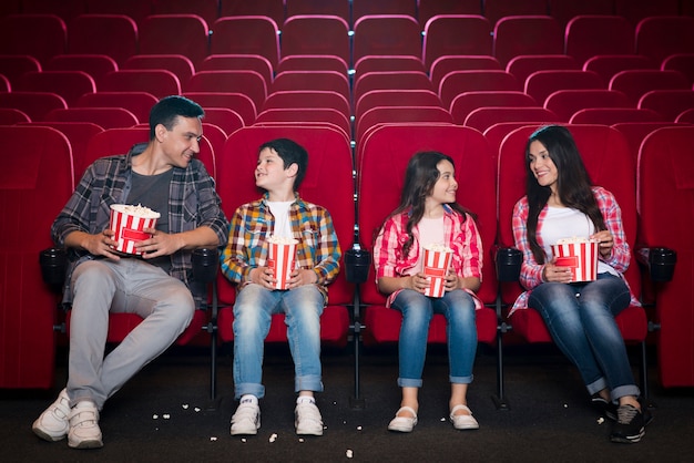 Familia feliz sentada en cine