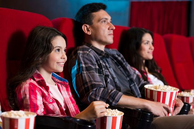 Foto gratuita familia feliz sentada en cine