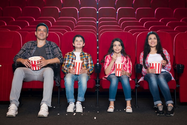 Familia feliz sentada en cine